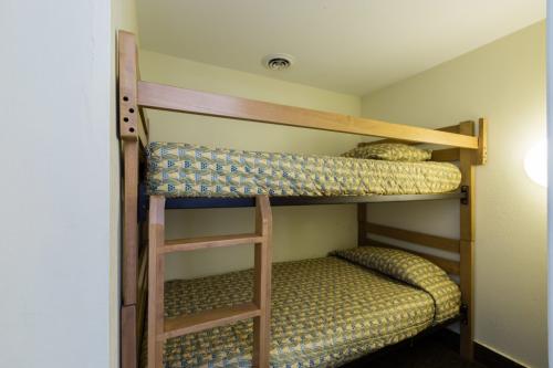 A bunk bed with wooden frame and patterned bedding