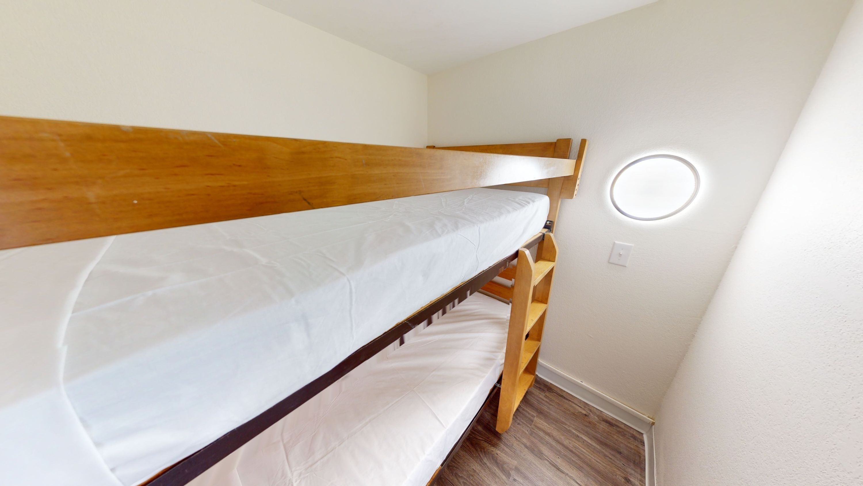 A room with bunk beds and a round window