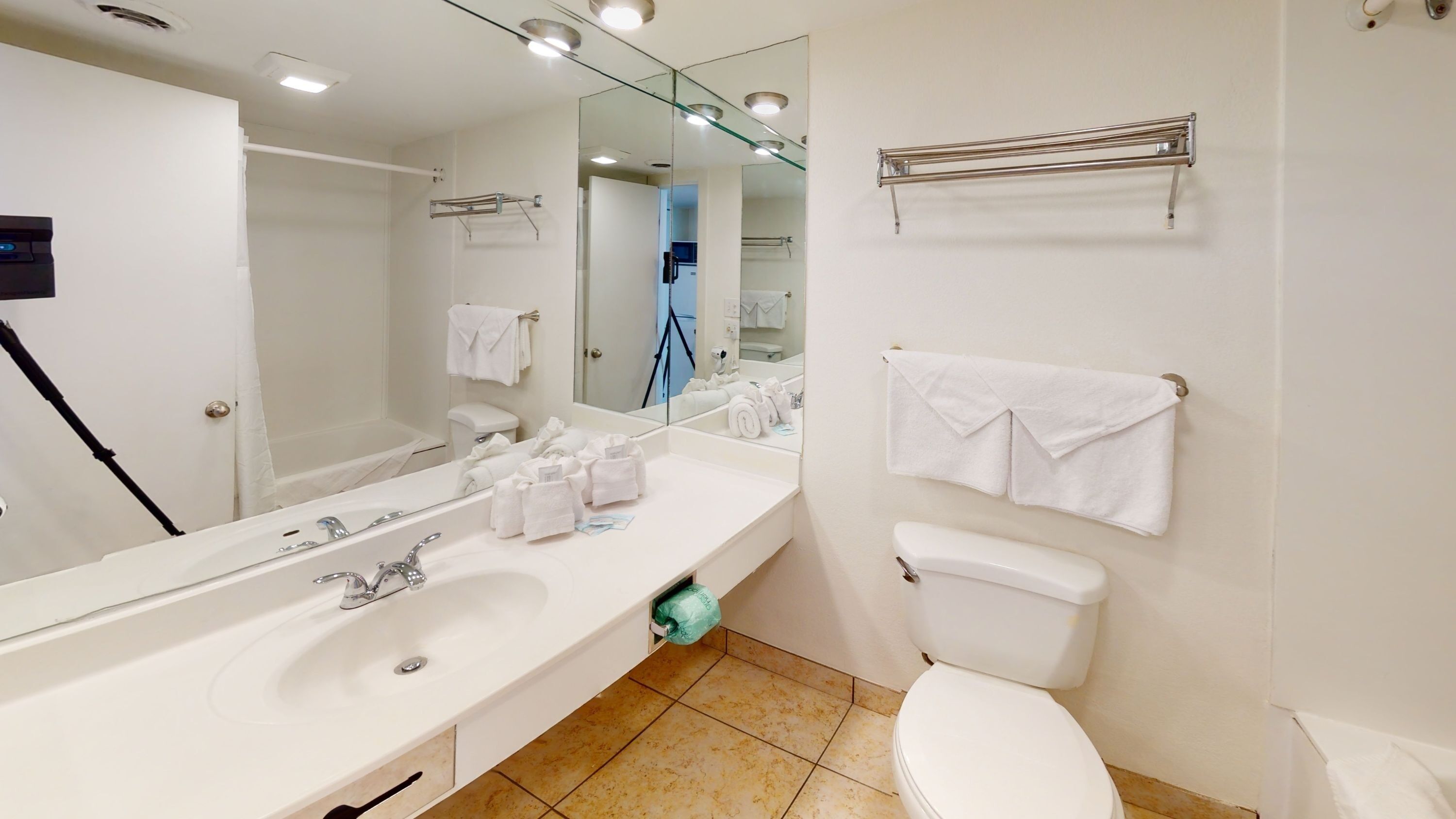 A clean bathroom with a double vanity, toilet, and shower